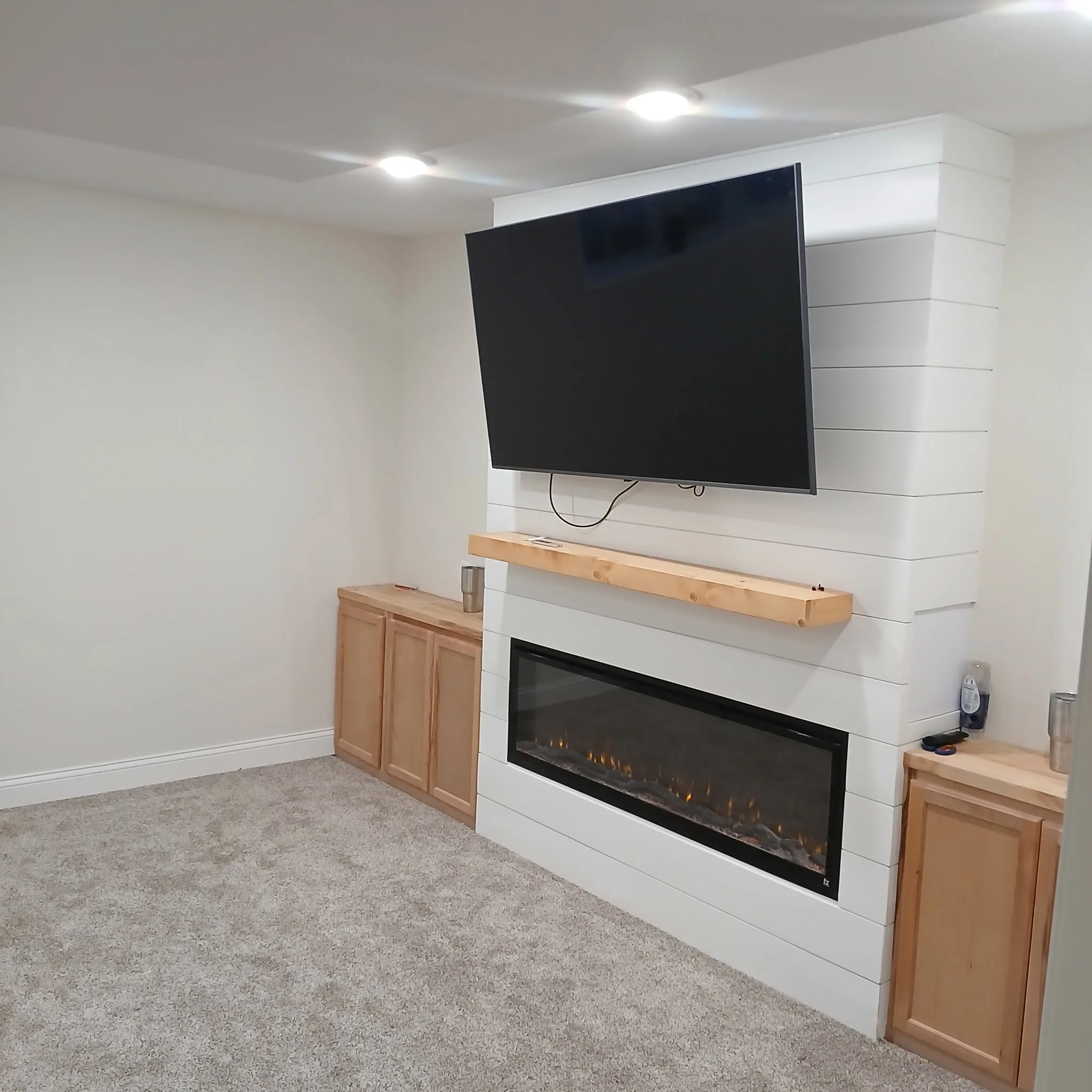 Finished basement with fireplace and shiplap TV wall